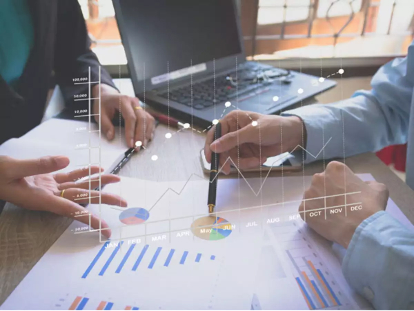 Anklyticx - A group of business people looking at graphs on paper.