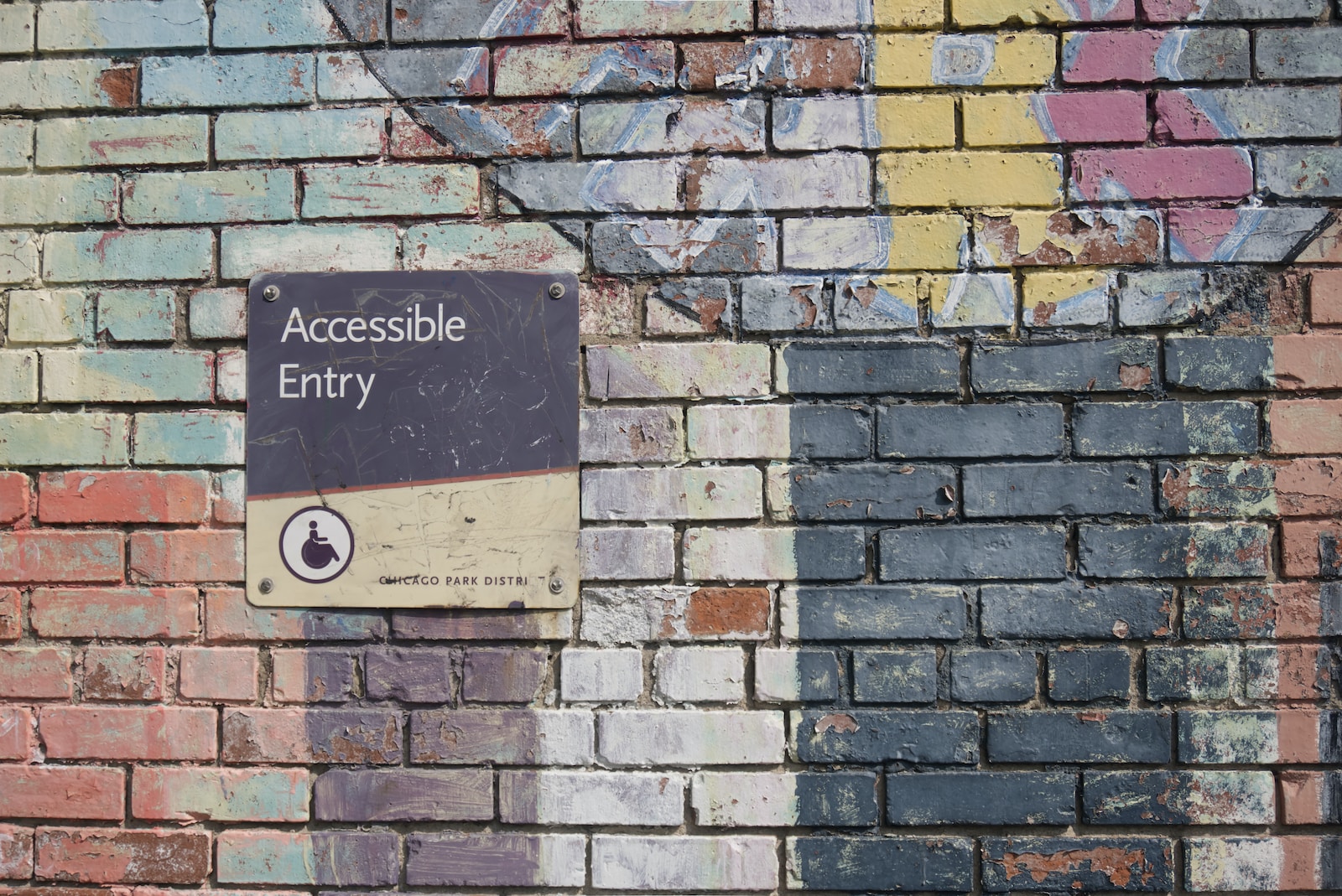 Anklyticx - A sign that says accessible entry on a brick wall.
